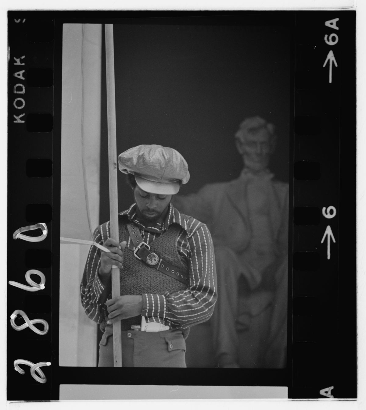 A Black person holding a flag at the Black Panther Party convention at the Lincoln Memorial in 1970.